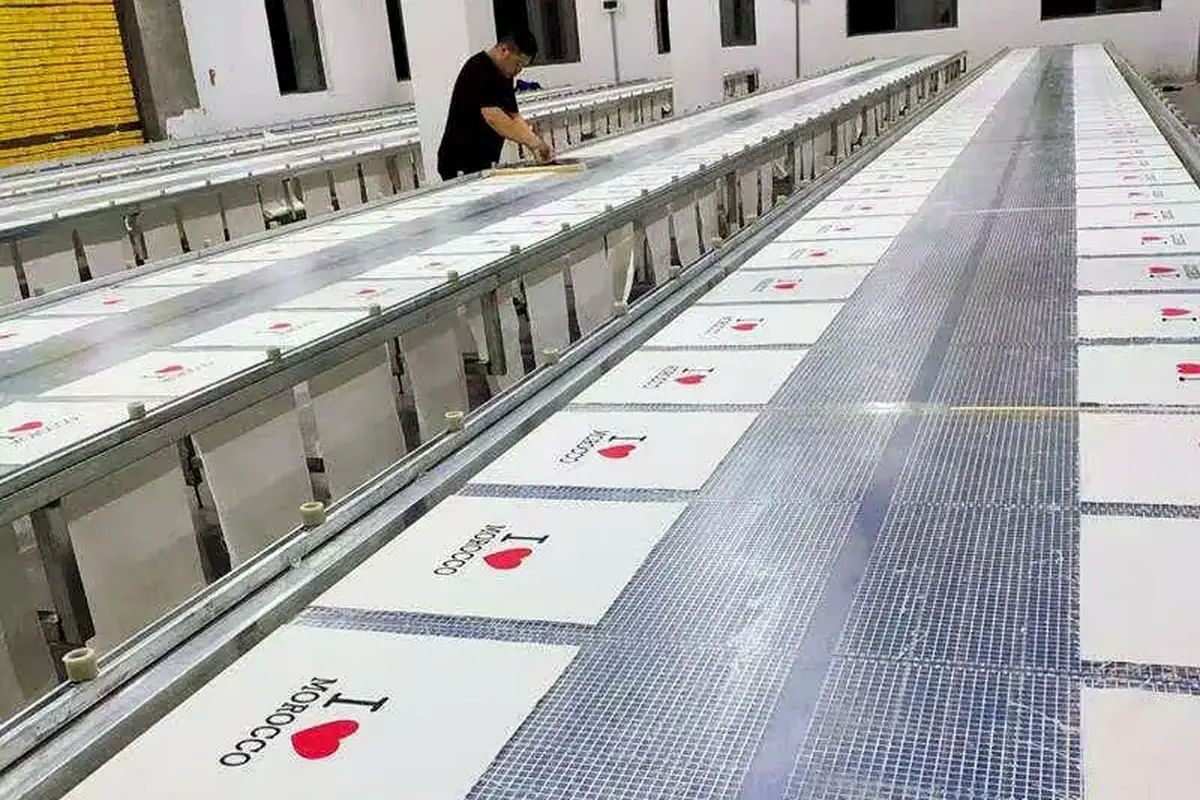 Operator working beside rows of printed tote bag panels.