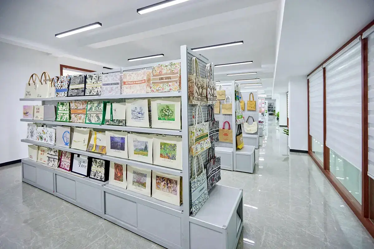 Printed tote bag samples displayed along a modern showroom aisle.