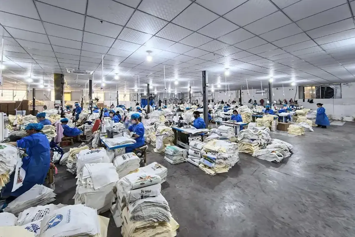 Tote bag production floor with sewing stations and sorted materials.