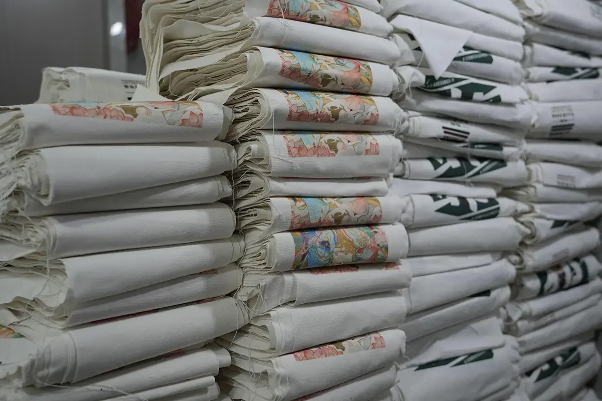 Stacks of finished printed tote bags in the factory workshop.