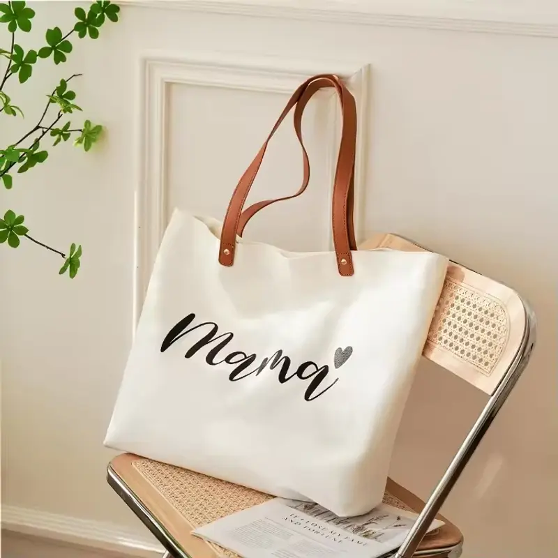 White wide-base canvas tote with brown handles and printed artwork.
