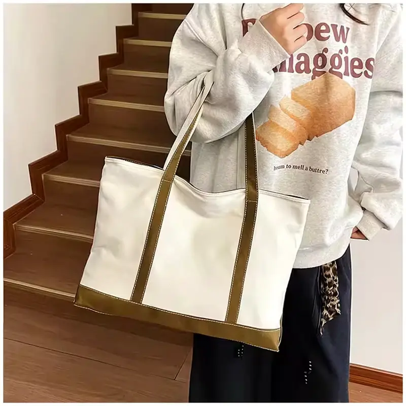 Large white canvas zipper tote with reinforced brown webbing.