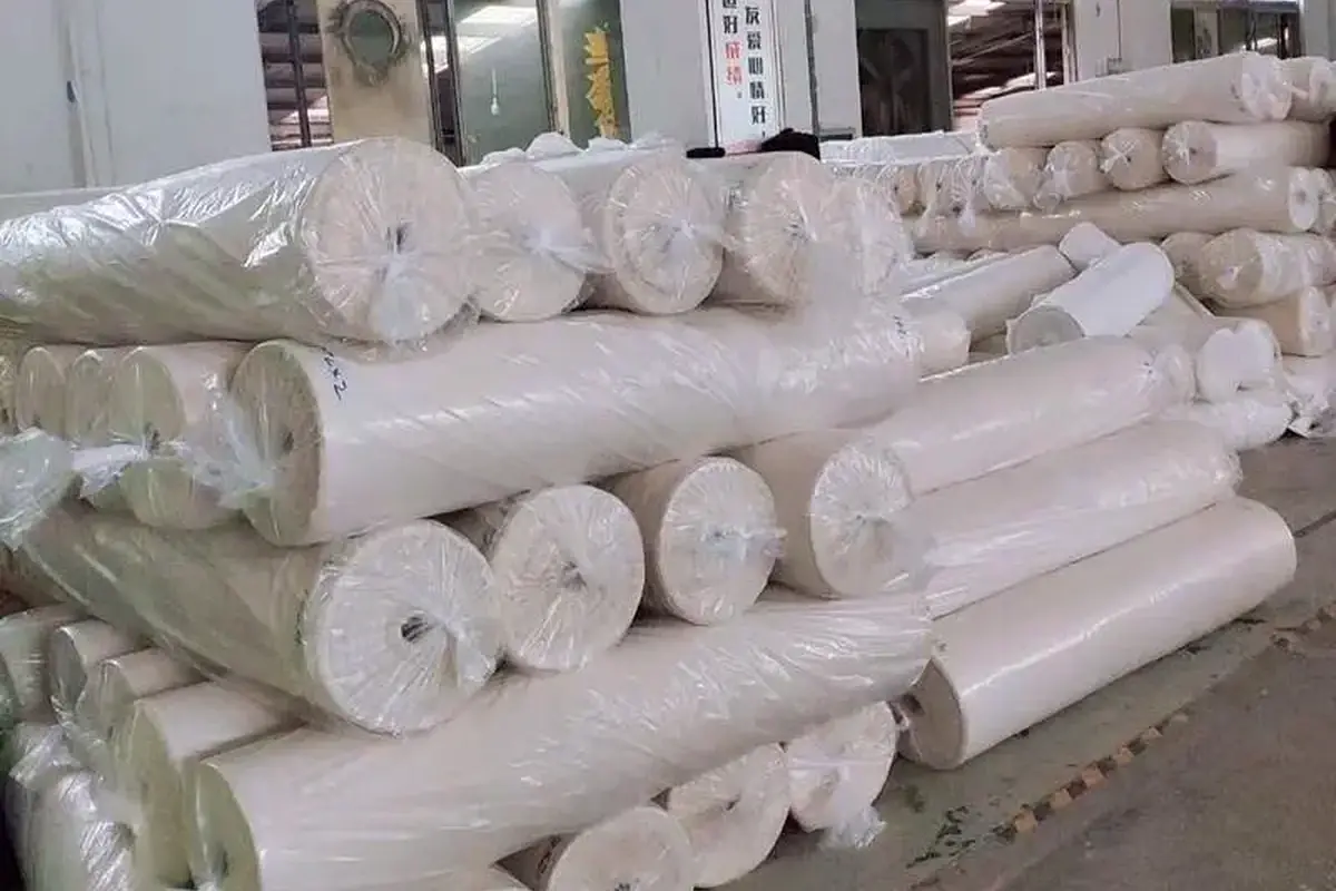 Fabric rolls prepared for custom tote bag material review.