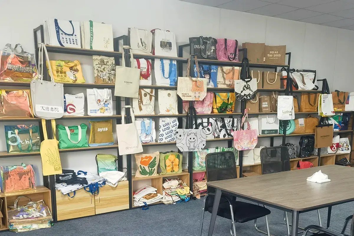Custom tote bag samples displayed beside a project review table.