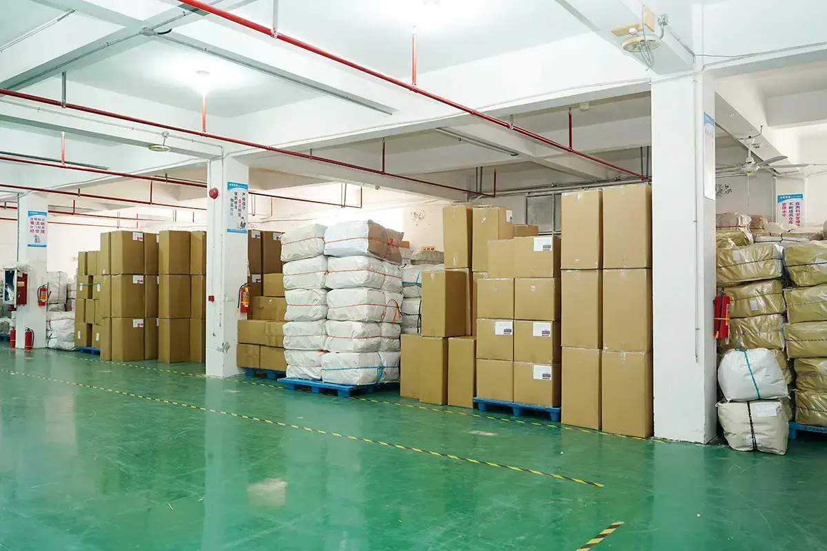 Packed cartons and wrapped tote bag bales stored on warehouse pallets.