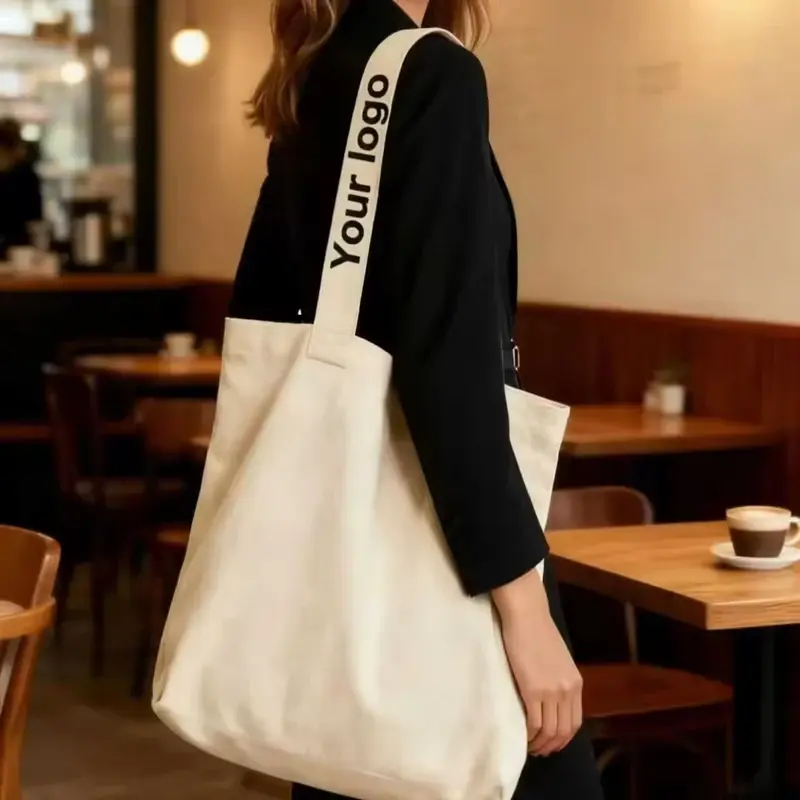 Model carrying a white 12 oz canvas tote over the shoulder