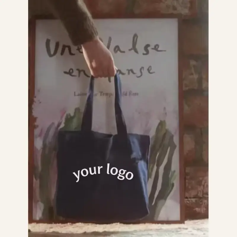 Dark heavyweight canvas tote carried by its long handles
