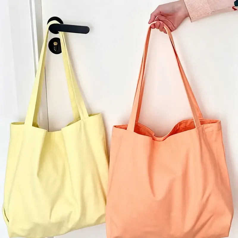 Two canvas tote bags in yellow and coral color options