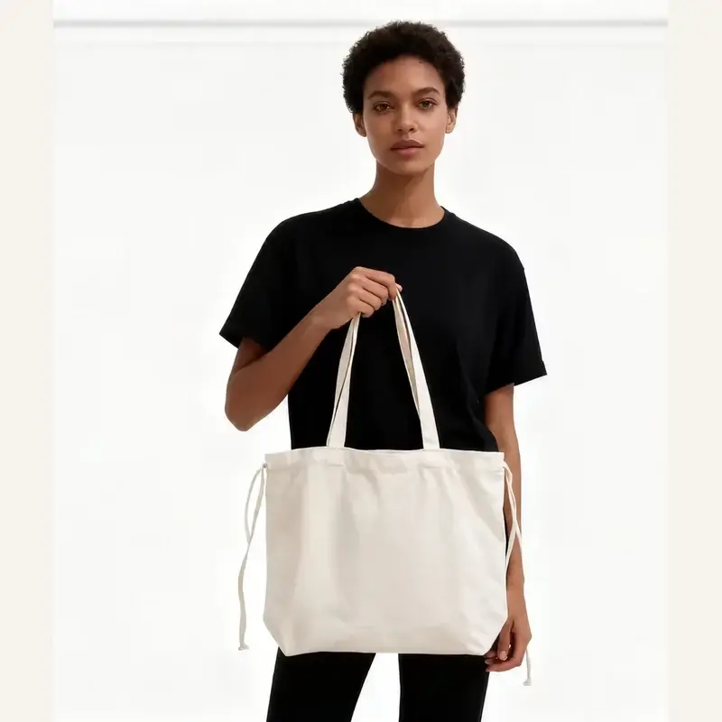 Natural canvas tote bag with inner pocket carried by a model