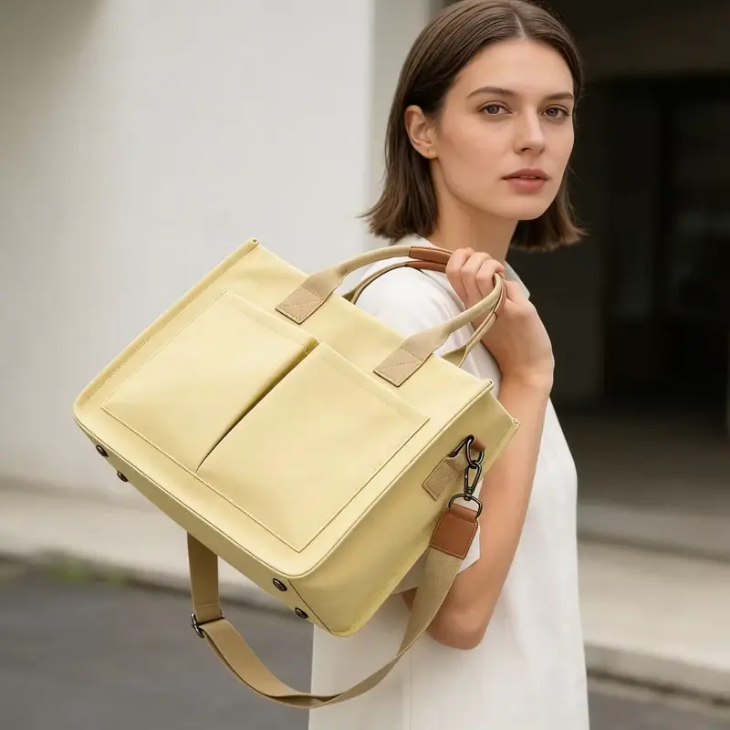 Yellow structured canvas tote with a top zipper carried by a model