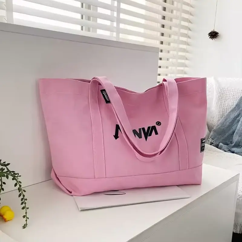 Pink canvas tote with a top zipper and long matching handles