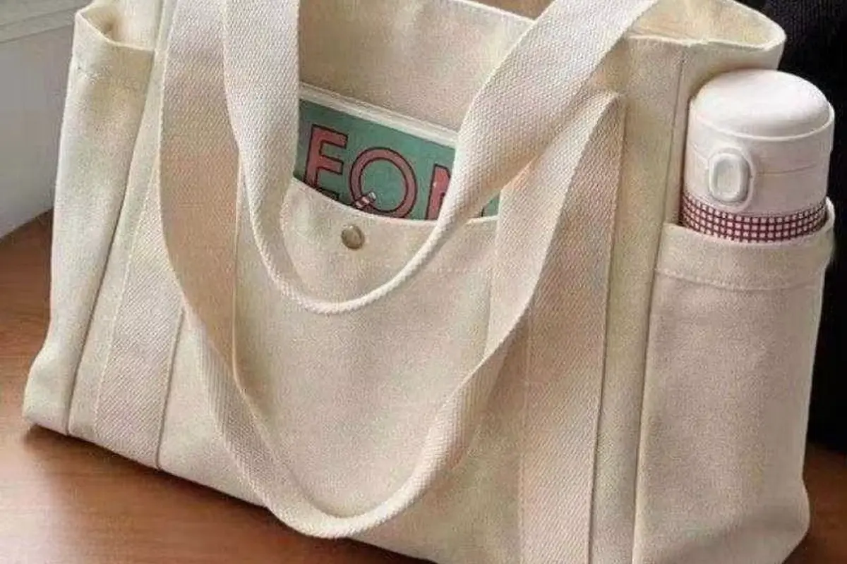 Natural cotton shopping tote loaded with books a bottle and small items