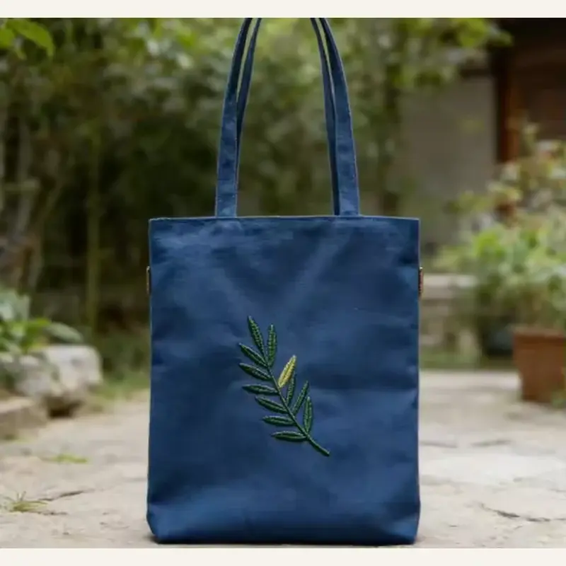 Navy cotton shopping tote with long handles and green leaf artwork