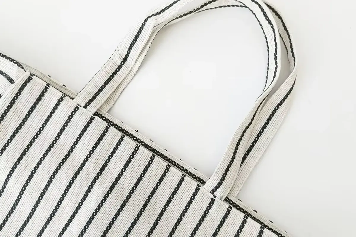 Close view of striped cotton fabric and reinforced shopper handles