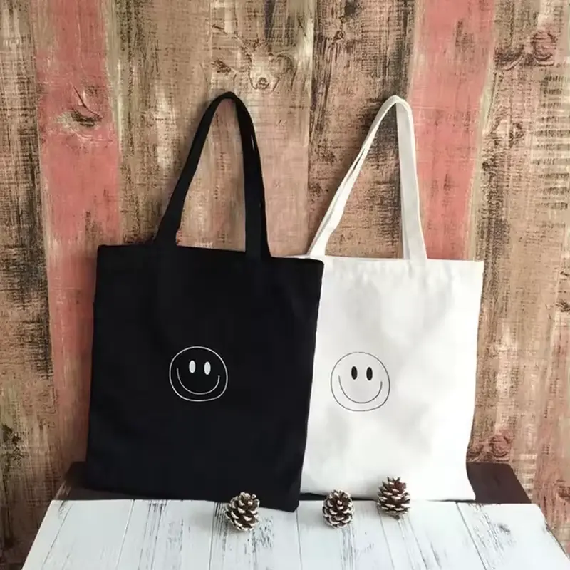 Black and natural cotton totes with long handles and sun artwork