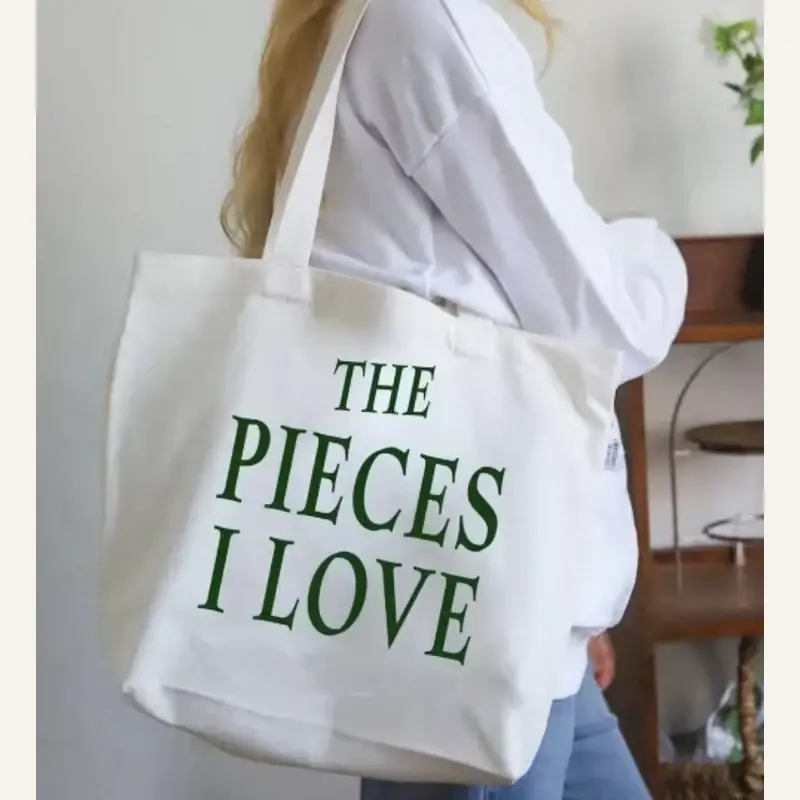 White cotton shoulder tote with long handles and green artwork