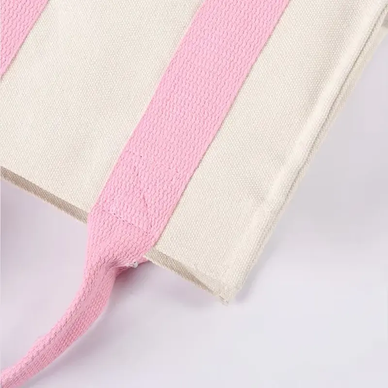 Pink webbing handle stitched over natural canvas