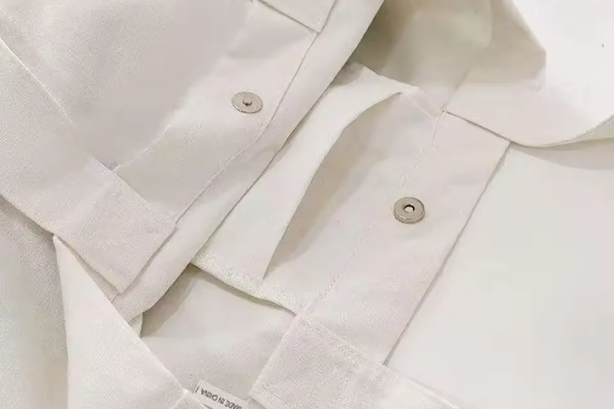 White canvas webbing and pocket seams with metal snap closures