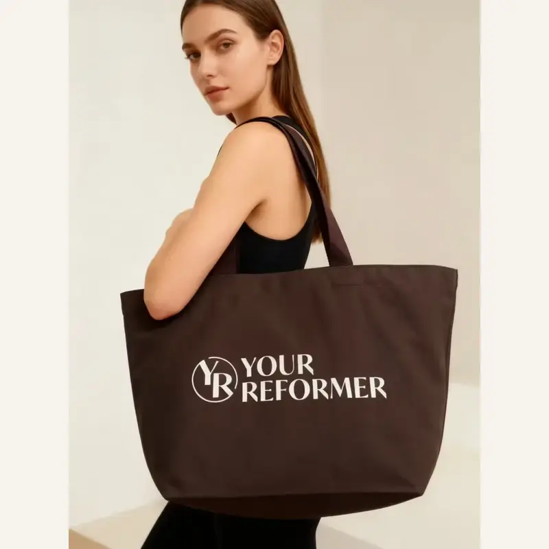 Brown heavy canvas tote carried at full size by a model