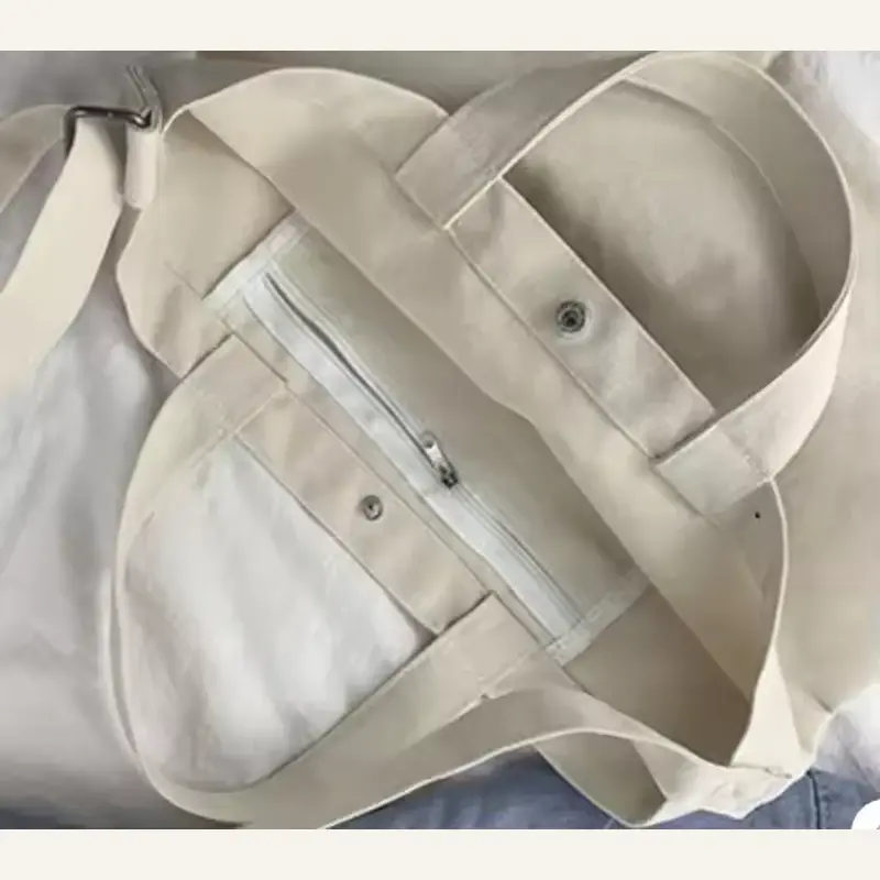 Natural canvas tote opened to show a zipper and inner pocket