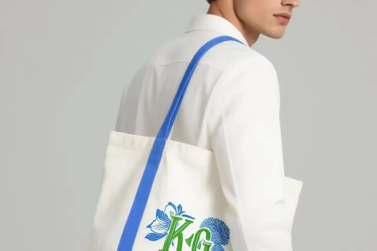 Natural cotton tote with blue handles and a matching blue side panel