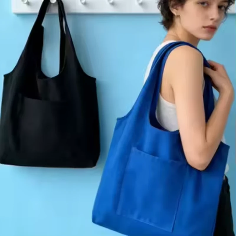 Blue lightweight cotton tote carried beside a black tote