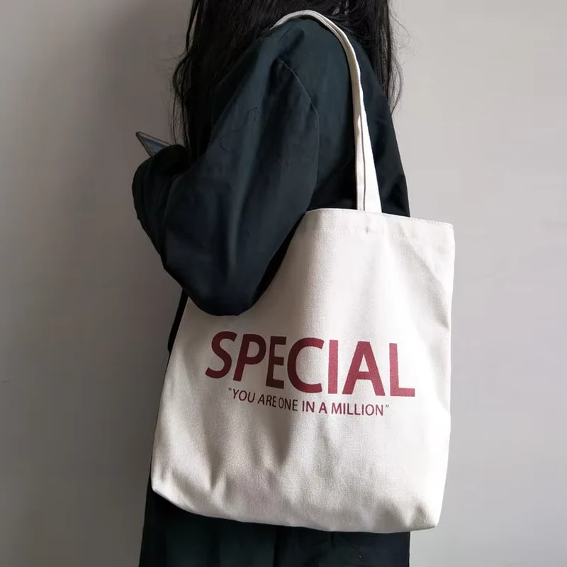 Natural classic canvas tote with brown handles and a small front print