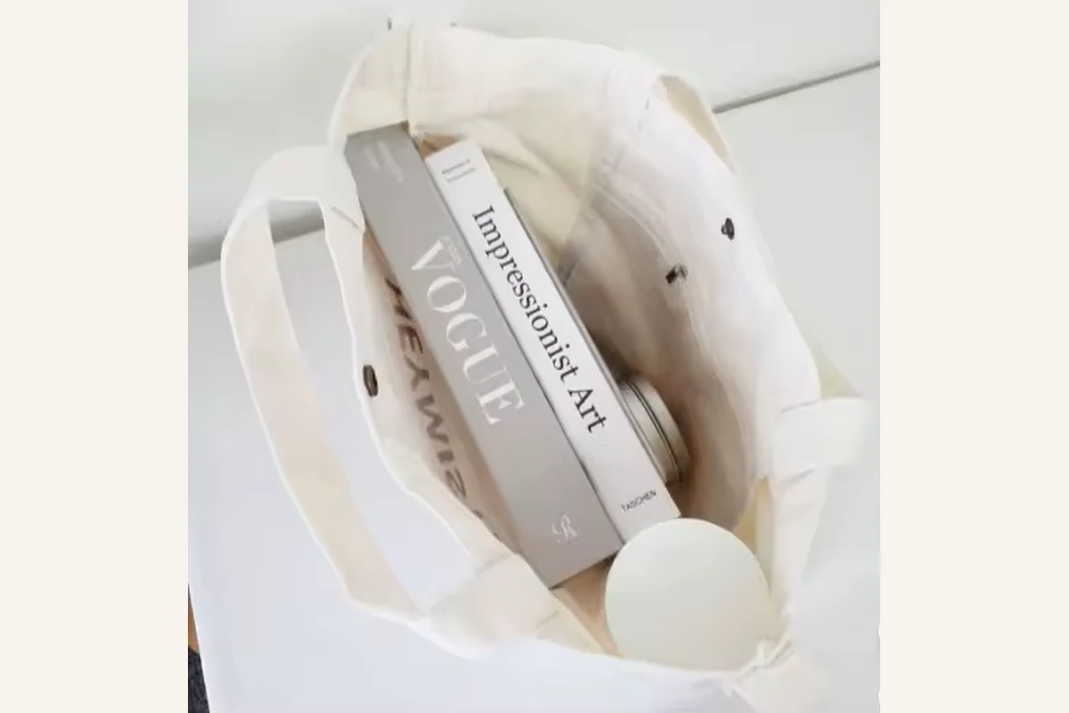Folded natural cotton tote with a slim box placed inside the bag
