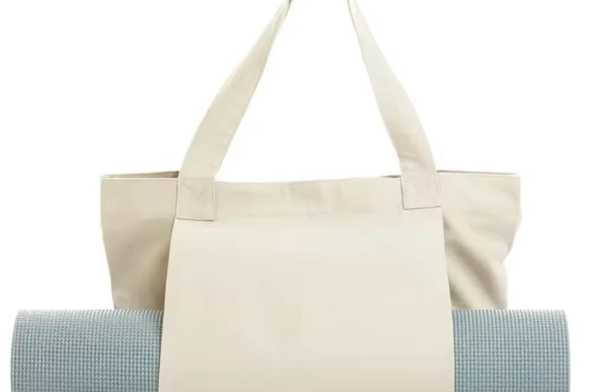 Two plain natural cotton totes displayed beside a rolled blue mat